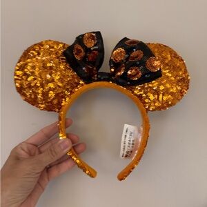 Disney Parks sequins gold orange Minnie ears with polka dot bow.